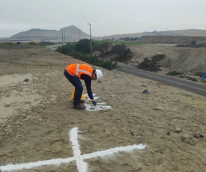 Integrante de Georamic marcando con cal un punto de fotocontrol junto a una vía